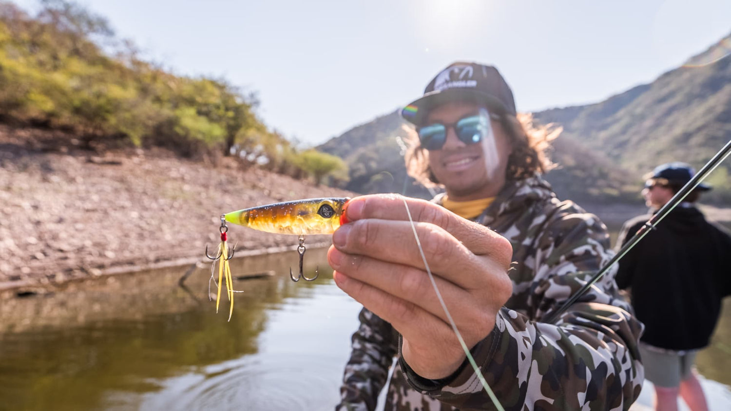 Angler holding a crankbait for bass fishing on a boat