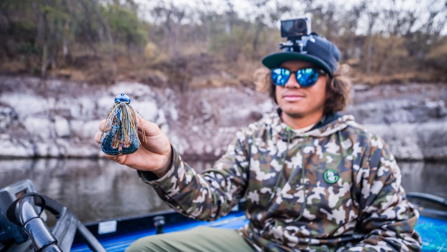 Angler holding a blue and black jig for pre-spawn bass fishing.