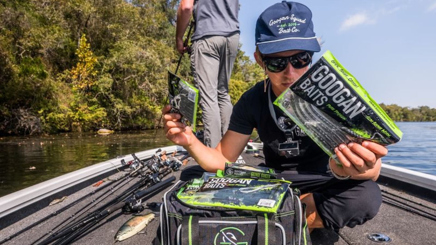 Angler comparing soft plastic bait colors on a fishing boat