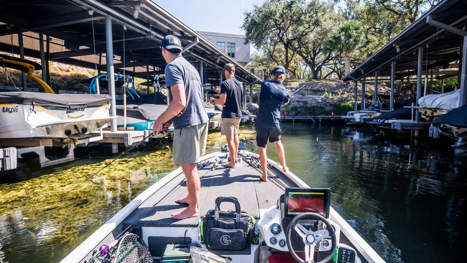 Anglers fishing the boat docks from a bass boat in early spring.