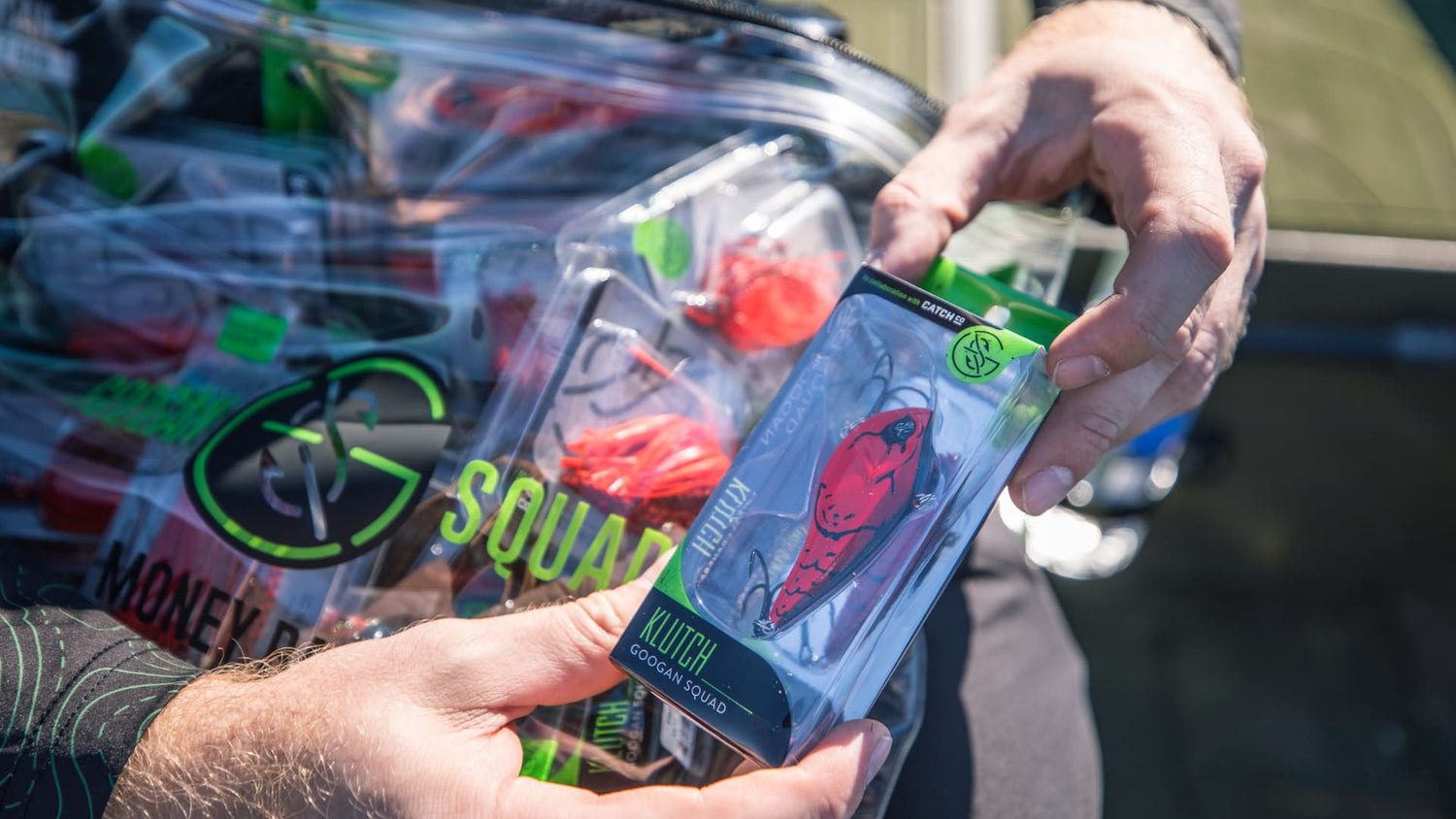 Red lipless crankbait in packaging held on boat deck before fishing