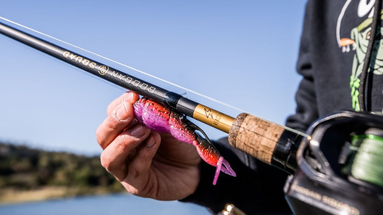Angler holding a rigged speed worm on a baitcaster for spring bass.